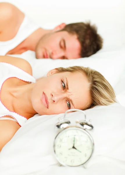 Couple malheureux couché sur leur lit — Photo