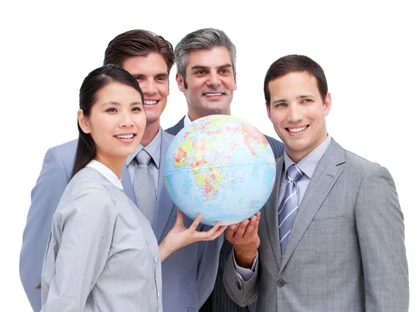 Säker businessteam titta på en terrestrial globe — Stockfoto