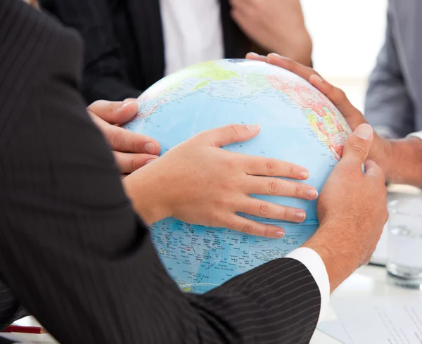 Close-up van een ernstige businessteam aanraken van terrestrische globe — Stockfoto