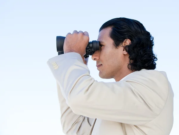 Retrato de um homem de negócios latino olhando através de binóculos — Fotografia de Stock
