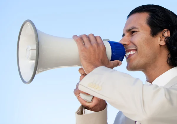 Portrait of an hispanic business man shouting through a megaphon — Stock Photo, Image