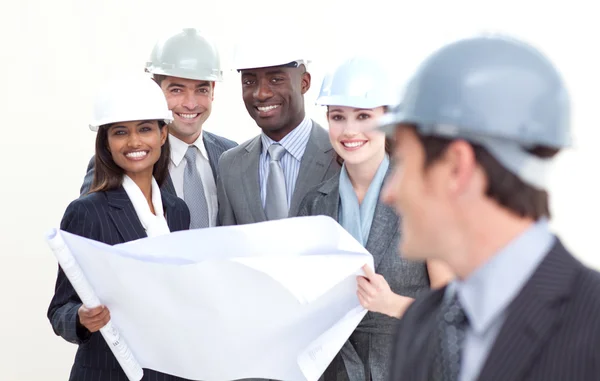 Engineer smiling at his team in the background — Stock Photo, Image