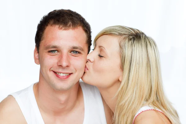 Beautiful woman kissing a smiling man — Stock Photo, Image