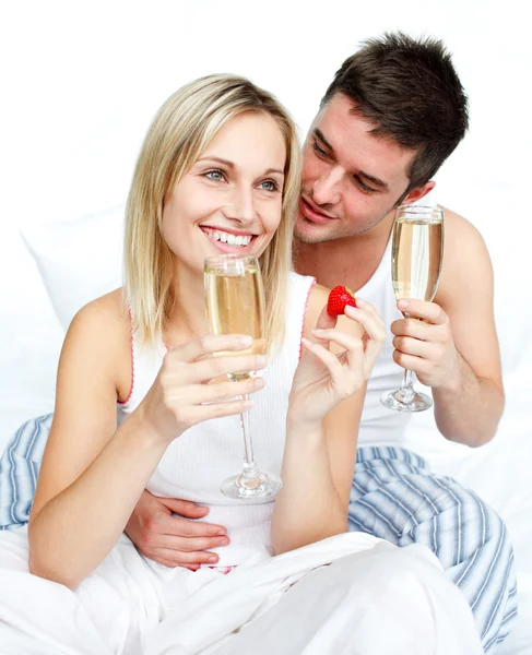 Amantes jóvenes comiendo fresas y bebiendo champán —  Fotos de Stock