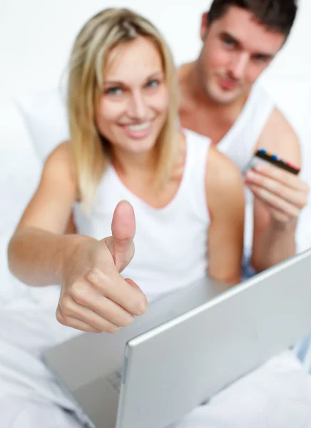 Couple in bed buying on-line successfully — Stock Photo, Image
