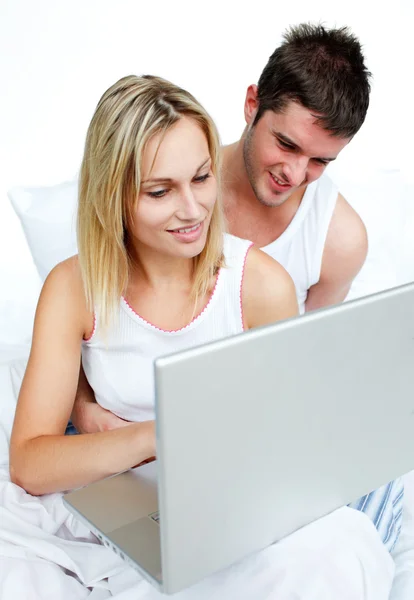 Par som använder en bärbar dator i sängen — Stockfoto
