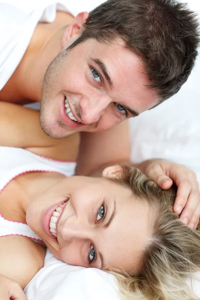 Sonrientes amantes acostados en la cama —  Fotos de Stock