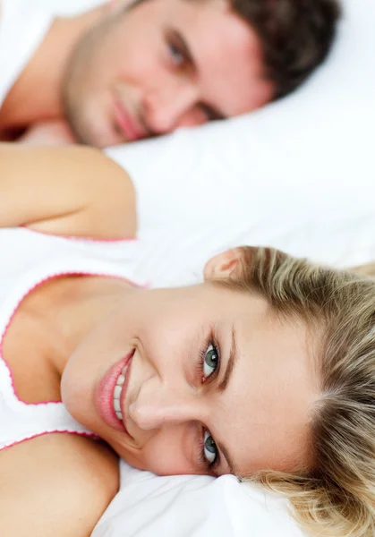 Beautiful smiling woman lying in bed with her boyfriend — Stock Photo, Image