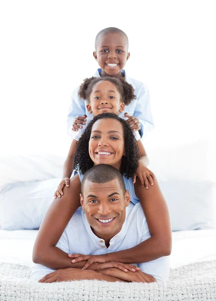 Familia animada divirtiéndose acostada en la cama — Foto de Stock