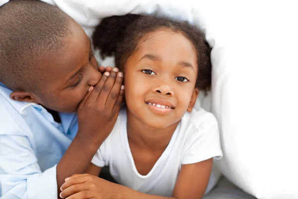 Adorable little boy whispering something to his sister — Stock Photo, Image