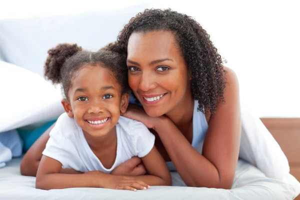 Affectionate woman and her daughter relaxing lying down on bed — Stock Photo, Image