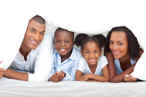 Merry family having fun lying down on bed — Stock Photo, Image