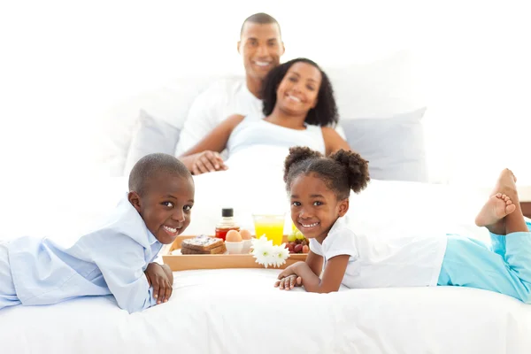 Família alegre tomando café da manhã no quarto — Fotografia de Stock