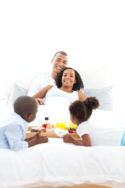 Joyful family having breakfast in the bedroom — Stock Photo, Image