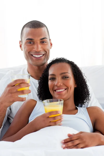 Enamored couple drinking lying on their bed — Stock Photo, Image