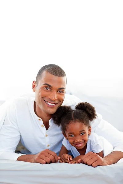Aufmerksamer Vater und seine Tochter lächeln in die Kamera — Stockfoto