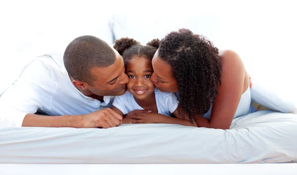 Cheerful parents kissing their daughter — Stock Photo, Image