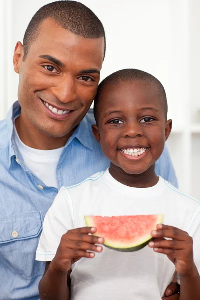 Portret chłopca uśmiechający się jedzenie owoców z ojcem — Zdjęcie stockowe