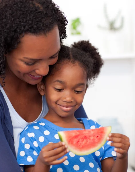 Menina bonita comendo melancia com sua mãe — Fotografia de Stock