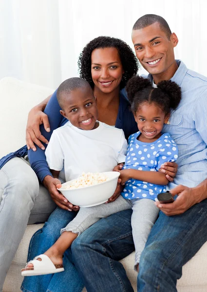 Портрет семьи, кушающей попкорн и смотрящей телевизор — стоковое фото