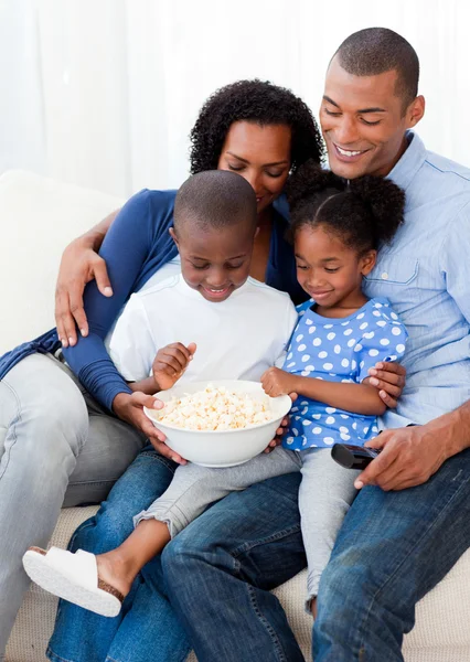 Lycklig familj äta popcorn och tittar på tv — Stockfoto
