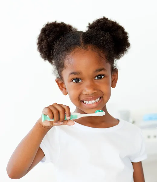 Portrait of an Afro-american girl brushing her teeth — Stock Photo, Image