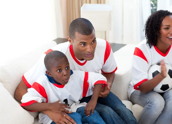 Lycklig familj tittar på en fotbollsmatch — Stockfoto