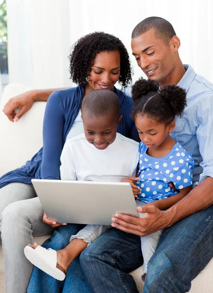 Mutlu bir aile bir dizüstü bilgisayar kullanarak — Stok fotoğraf