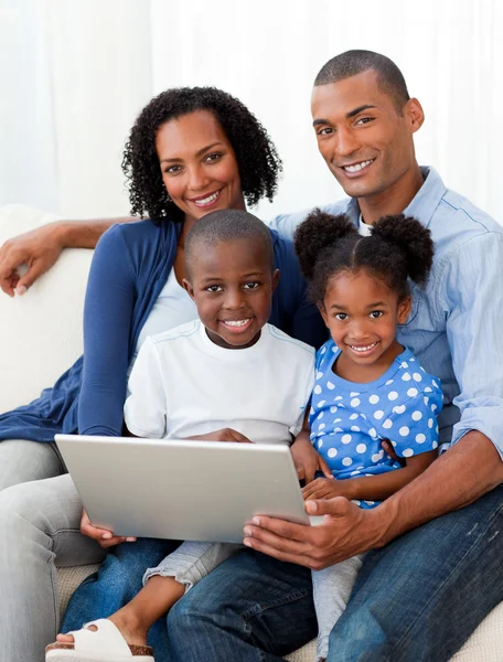 Χαμογελώντας αφρο-αμερικανικό οικογένεια χρησιμοποιώντας ένα φορητό υπολογιστή — Φωτογραφία Αρχείου