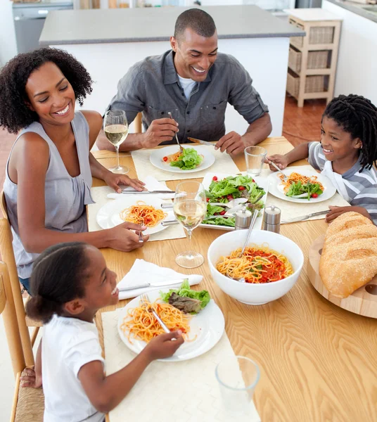 Lächelnde Familie beim gemeinsamen Essen — Stockfoto