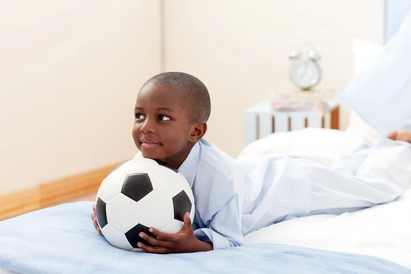 Glad liten pojke som håller en fotboll — Stockfoto