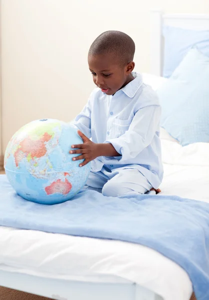 Liten pojke håller en terrestrial globe — Stockfoto