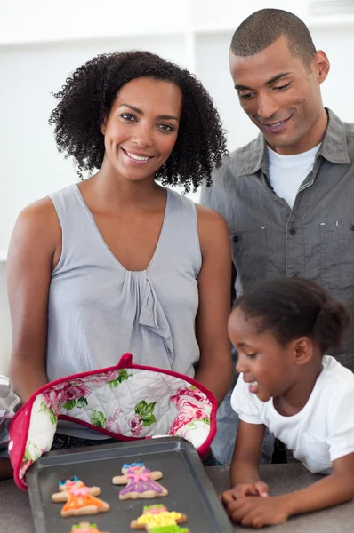 Lächelnde Familie zeigt handgemachte Plätzchen — Stockfoto