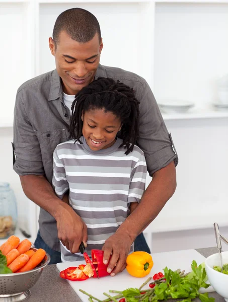 Padre atento ayudando a su hijo a cortar verduras — Foto de Stock