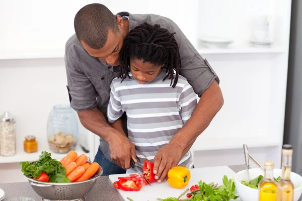 Liebender Vater hilft seinem Sohn beim Gemüseschneiden — Stockfoto