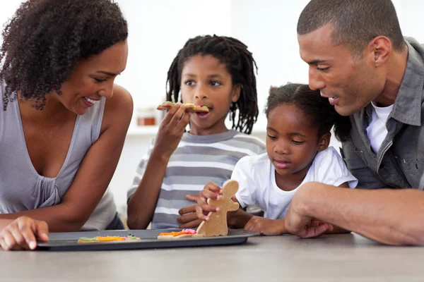 Família afro-americana feliz comer biscoitos caseiros — Fotografia de Stock