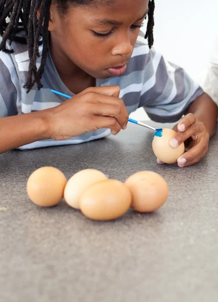 Lindo niño afroamericano pintando huevos — Foto de Stock