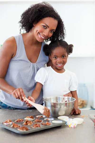 Внимательная мать помогает своей девочке готовить печенье — стоковое фото