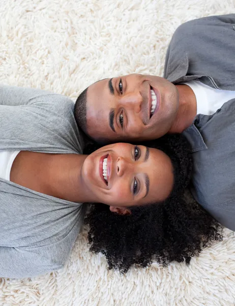 Sorridente coppia afro-americana sdraiata sul pavimento — Foto Stock