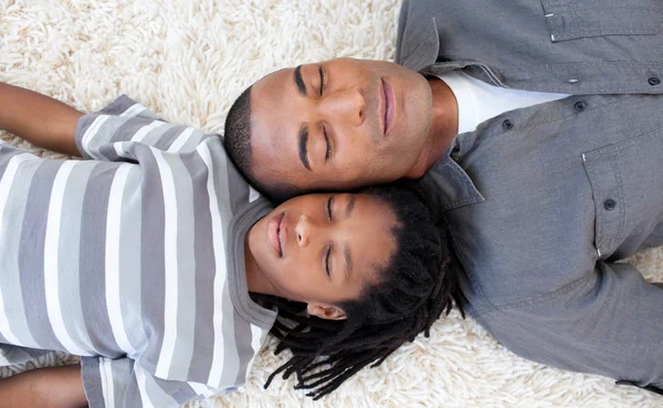 Père et fils afro-américains dormant par terre — Photo