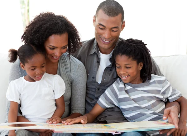 Afro-Amerikaanse familie lezen van een boek in de woonkamer — Stockfoto