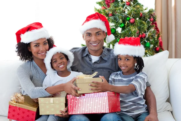 Glimlachen van Afro-Amerikaanse familie kerstcadeautjes delen — Stockfoto