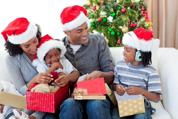 Happy Afro-American family opening Christmas presents — Stock Photo, Image