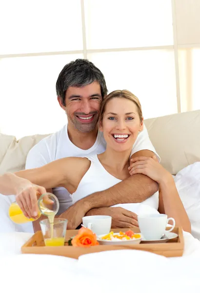 Casal romântico tomando café da manhã deitado na cama — Fotografia de Stock