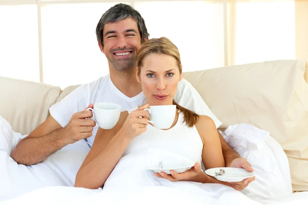 Intimní pár pití kávy ležící v posteli — Stock fotografie