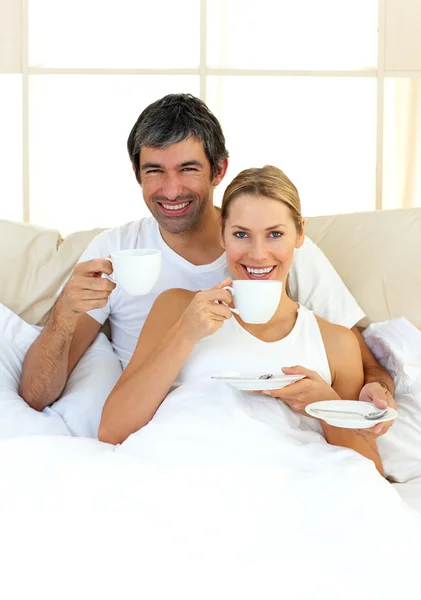 Nadšení milovníci pití kávy ležící v posteli — Stock fotografie