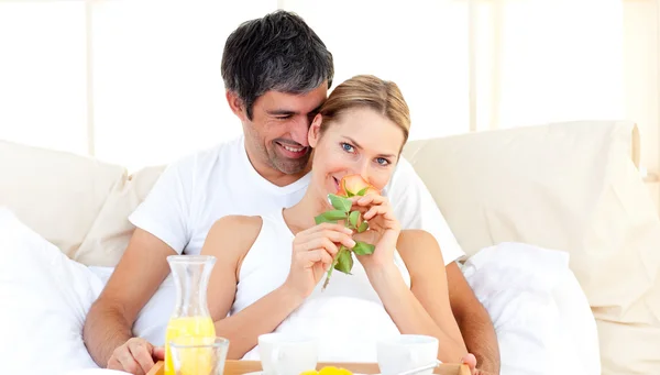 Casal caucasiano tomando café da manhã deitado na cama — Fotografia de Stock