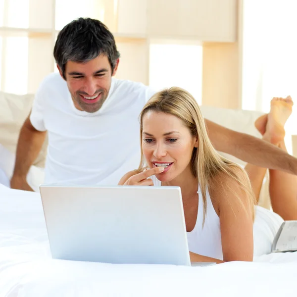 단정적인 여자 침대에 누워 노트북을 사용 하 여 — 스톡 사진