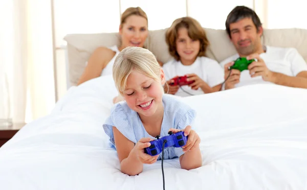 Cute blond child playing video game with her family — Stock Photo, Image