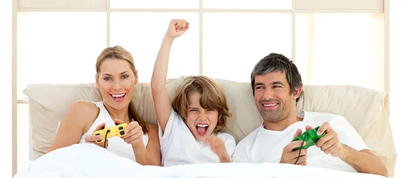 Smiling little boy playing video game with his family — Stock Photo, Image